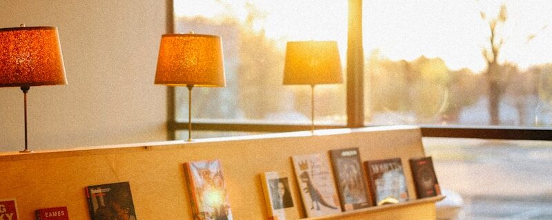 A library area with tables and lamps lit.