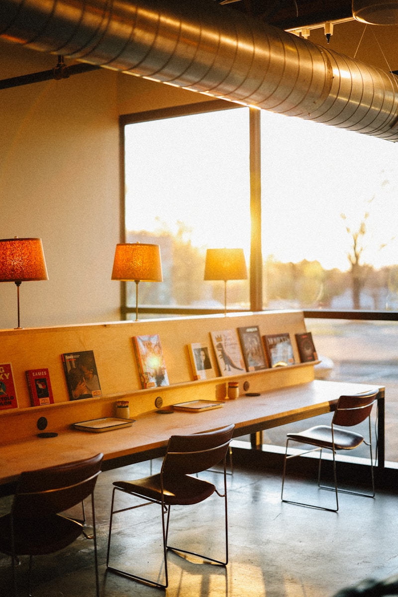 A library area with tables and lamps lit.
